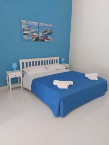 a blue bedroom with a bed with towels on it at affittacamere lu mari lu suli lu ventu in Gela