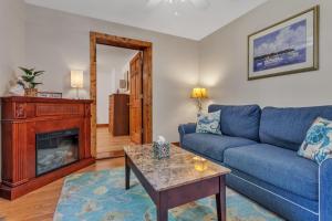 a living room with a blue couch and a fireplace at Cozy Bungalow Just Minutes from Mystic, Westerly Beaches, Boating and Casinos! bungalow in Groton