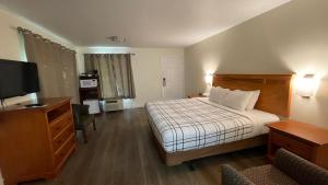 Milton-FreewaterにあるMorgan Inn and Suites Walla Wallaのベッドとテレビが備わるホテルルームです。