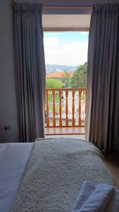a bedroom with a bed and a view of a balcony at Hotel Aural in Cajamarca
