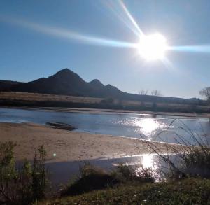 vistas a un río con el sol en el cielo en Casas de Campo Famailla en Nono