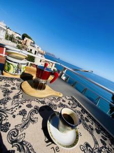 uma mesa com copos e pires numa varanda com vista para o oceano em Palermo relax family house em Altavilla Milicia