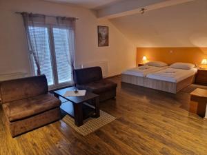 a hotel room with a bed and a couch and a chair at Plitvice Palace in Grabovac