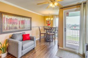 a living room with a chair and a balcony at Sands Beach Club Condo with Ocean Views and Amenities! in Myrtle Beach