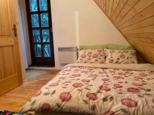 a bedroom with a bed with a floral comforter at Moonica Rujiste in Mostar
