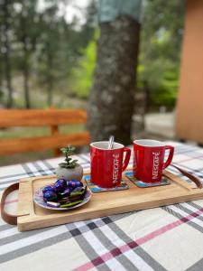 uma bandeja com duas chávenas vermelhas e snacks numa mesa em Moonica Rujiste em Mostar