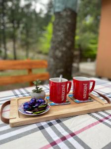 Una bandeja con dos tazas rojas y bocadillos sobre una mesa. en Moonica Rujiste, en Mostar