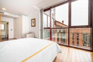 a bedroom with a white bed and a large window at Chueca Gran Via Recoletos Libertad 24 12 in Madrid