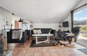 a living room with a couch and a table and chairs at Stunning Home In Thisted With 4 Bedrooms, Sauna And Wifi in Nørre Vorupør