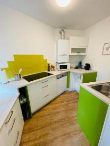 a kitchen with green and white counters and a sink at Schickes Messe Appartement mitten in Essen in Essen