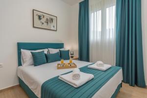 a bedroom with a large bed with towels on it at Apartments Bonazza in Petrovac na Moru