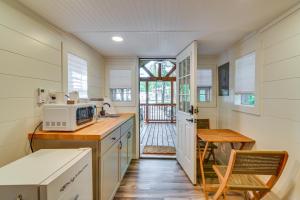 cocina con microondas, mesa y puerta en Contemporary Starkville Tiny Cabin 3 Mi to MSU!, en Starkville