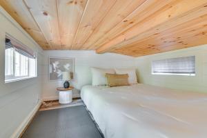 Ce lit se trouve dans une petite chambre dotée d'un plafond en bois. dans l'établissement Contemporary Starkville Tiny Cabin 3 Mi to MSU!, à Starkville