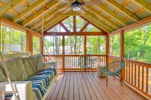 une terrasse couverte avec un canapé et des chaises sur une terrasse en bois dans l'établissement Contemporary Starkville Tiny Cabin 3 Mi to MSU!, à Starkville
