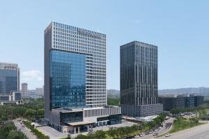 two tall glass buildings in a city with a street at Sheraton Xi'an South in Xi'an