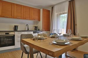 eine Küche mit einem Holztisch mit Weingläsern darauf in der Unterkunft Apartment SB77 Leogang in Leogang