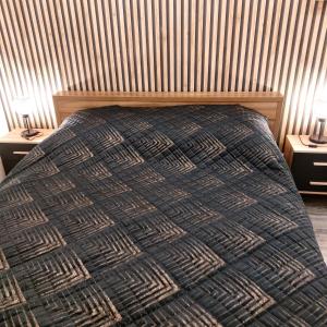 a bedroom with a bed and two night stands with lamps at Apartament przy Białym Koniu in Koszalin