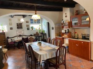 a kitchen and dining room with a table and chairs at Véndektanya Vendégház in Tapolca