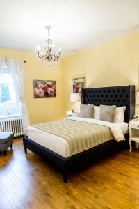 Un dormitorio con una cama grande y una lámpara de araña. en Manoir Becancourt Hotel en Bécancour