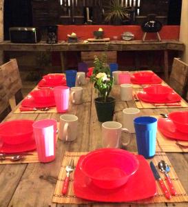 a wooden table topped with red plates and red cups at Sunset Paradise - Todos Santos in Todos Santos