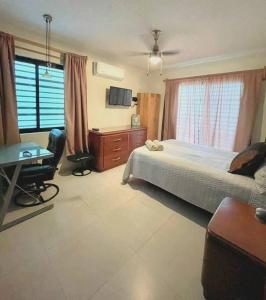 1 dormitorio con cama, escritorio y mesa en Hermoso departamento en Paseo Santa Lucia en Monterrey