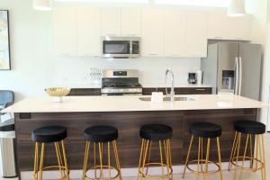 a kitchen with a counter with stools and a sink at Modern Minimalist Luxury Retreat in Houston