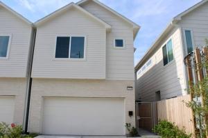 une maison blanche avec un garage blanc dans l'établissement Modern Minimalist Luxury Retreat, à Houston