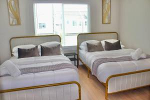 duas camas sentadas uma ao lado da outra num quarto em Modern Minimalist Luxury Retreat em Houston