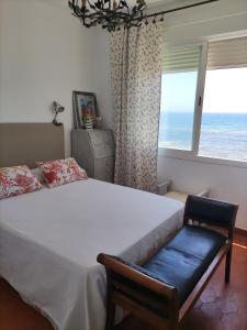 a bedroom with a bed and a window with the ocean at Caños de Meca Apartamento frente al mar in Los Caños de Meca