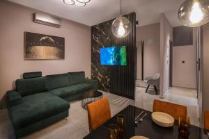 a living room with a green couch and a table at Maison 4 Seasons in Kalamata