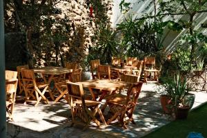 un grupo de mesas y sillas de madera en un jardín en Leveli Coliving en Guadalajara
