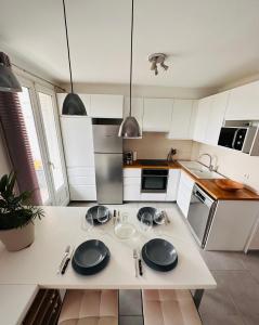 een keuken met witte kasten en zwarte borden op een aanrecht bij Le soulier de notre dame in Marseille