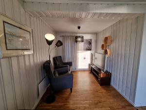 sala de estar con silla y TV en Nappstraumen Seaview holiday home en Haug