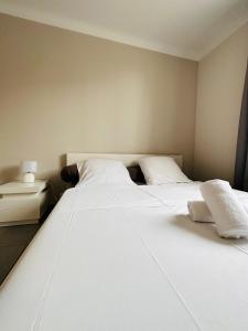 een slaapkamer met 2 witte bedden en een nachtkastje bij Le soulier de notre dame in Marseille +13 foto's