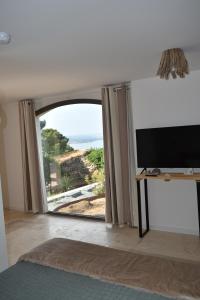 a living room with a tv and a sliding glass door at Dbarka7 in Sète
