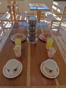 un tavolo in legno con piatti e bicchieri di succo d'arancia di H.Espejo a Copacabana