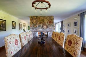 a dining room with a table and chairs and a stone fireplace at Escape to A Luxury Country Home 