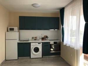 a kitchen with green cabinets and a washing machine at Борис in Ravda