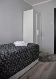 a bedroom with a bed and a closet with towels on it at Bohaterów Modlina Point by sleepwell in Nowy Dwór Mazowiecki