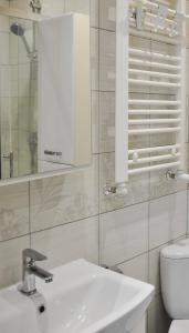 biała łazienka z umywalką i toaletą w obiekcie Bohaterów Modlina Point by sleepwell w Nowym Dworze Mazowieckim