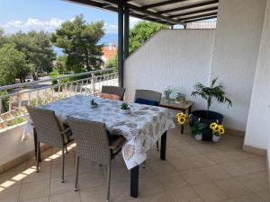 a table and chairs on a balcony with a view at Apartment Jasna B in Omišalj