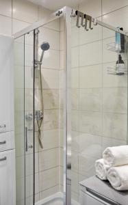 a shower with a glass door in a bathroom at Bohaterów Modlina Point by sleepwell in Nowy Dwór Mazowiecki