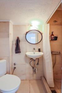 a bathroom with a sink and a toilet and a mirror at Mini Suite Roman Agora in Thessaloniki