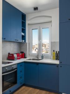 a blue kitchen with a sink and a window at Corfu Lux City in Agios Rokkos