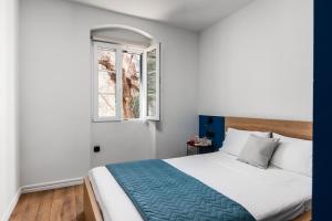 een slaapkamer met een bed en een raam bij Corfu Lux City in Ágios Rókkos