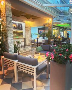 a patio with couches and tables in a restaurant at Hotel Rosmary in Lido di Jesolo