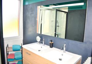 a bathroom with a white sink and a mirror at À 2mn de la plage, maison avec grand terrain clos in Plérin