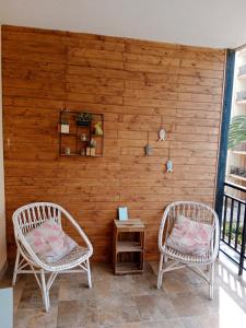 two chairs on a porch with a wooden wall at caracas in Salou