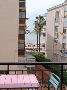 a balcony with a pink bench and a view of the beach at caracas in Salou