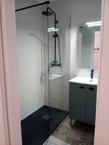 a shower with a glass door next to a sink at caracas in Salou